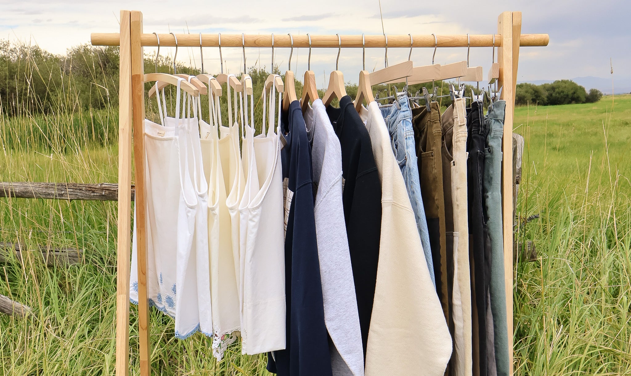 Clothing rack with clothes hanging outdoors in a field